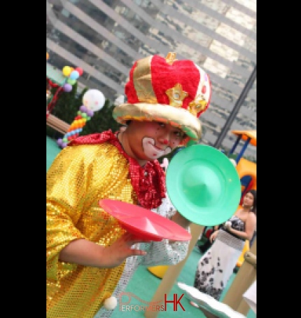 Roving juggling clown in Hong Kong posting with two juggling plates at a corporate family day