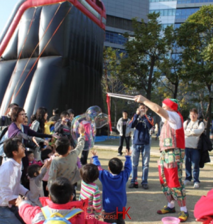 The children is trying to catch the bubbles at a Hong Kong corporate Christmas event