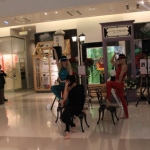 Dancers using chairs as props and rocking hats during their performance. 