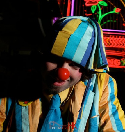 Alfie wears colourful clothes and red nose for his performances