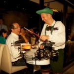Drummer performing in restaurant, laughing with guests