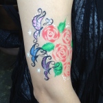 Butterfly and rose paints on arm.