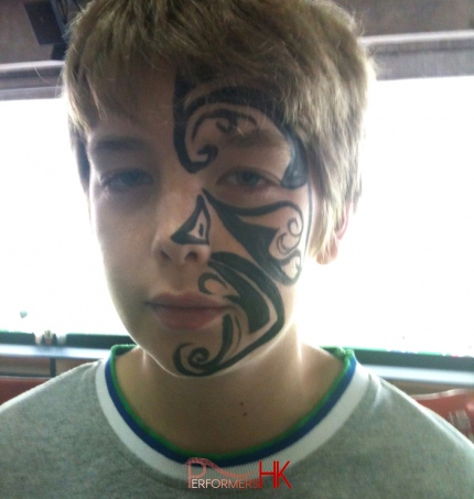 Hong Kong professional face painter paint a tattoo style face paint for boys at a corporate Xmas event.