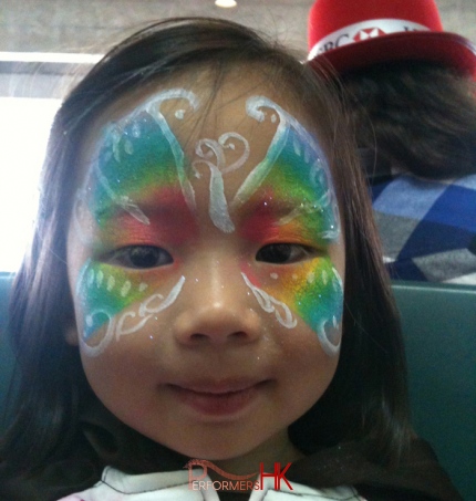A Facepainter designed a rainbow butterfly face painter a a girl at the Hong Kong HSBC Xmas function.