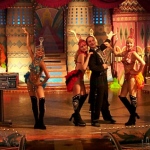 Magician and his female dancers posing after their instant costume changes. 
