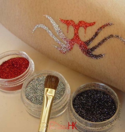 A glittering tattoo with red , sliver and black glitter by artist at a corporate event.