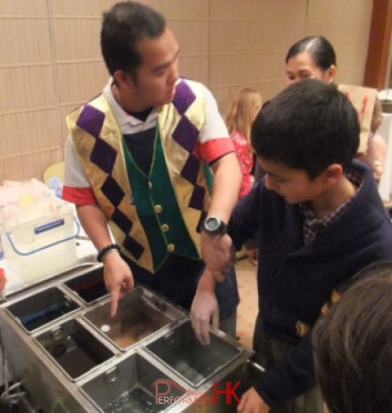 Wax hand operator about to dip a small boys hand in the waz