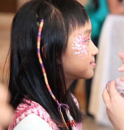 Child got a braid wrap with a colorful string at a festival event
