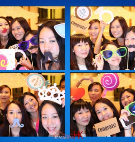 ladies wearing funny props taking pictures at photobooth stall