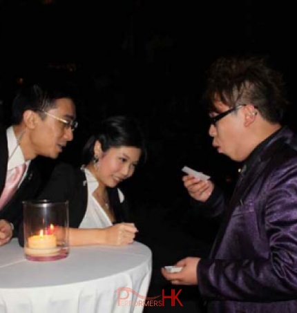 Magician in Hong Kong performing roving magic to two guests at a corporate cocktail event