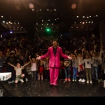 Hong Kong stage magician taking a picture with his audience after his performance at a corporate children event 