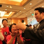 magician performing roving card magic to runner at the Li & Fung Standard Chartered Hong Kong Marathon after party in Regal Hotel
