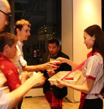 Model serving pop corn in 8oz containers at an event with a cinema themed event, guests happily taking the pop corn