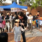 Magician performing three linking rings magic with a children audience at Hong Kong Kowloon Park 