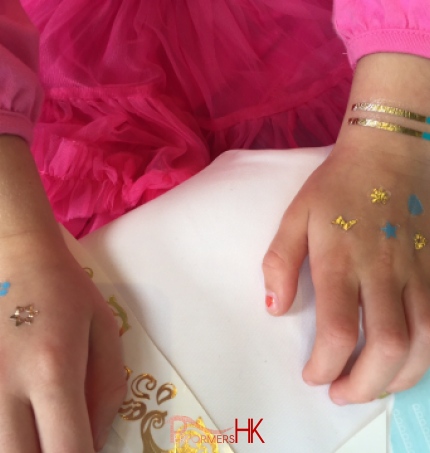 A Hong Kong Kid have ten henna style temporary  tattoos on her hands at a family function