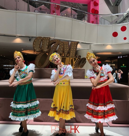 3 girls in different color costumes doing russian folk dance