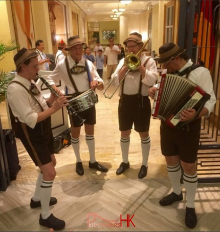 oktoberfest band playing music in a laderhosen and full outfit with accordion and brass section