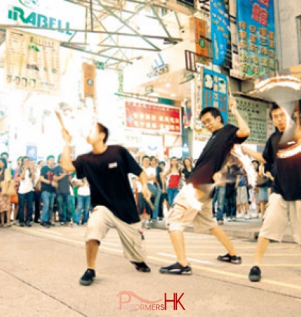 Three fire juggler performing a combined fire show in Hong Kong Causeway Bay