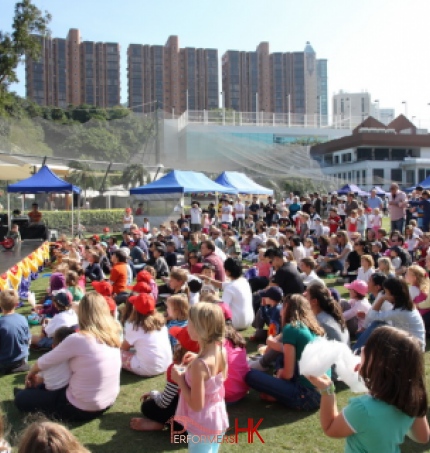 Magician Juggler at the Hong Kong cricket club doing a stage with a huge family crowd seated in front