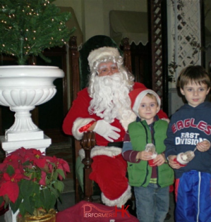 Professional Santa in HK greeting and taking picture with the kids at a Christmas event.