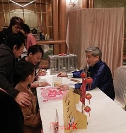 The Hong Kong bird fortune telling master explaining the card to five ladies at a corporate event