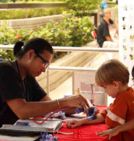 Tattoo artist applying temporary tattoo for 2 kids during a fun day out 