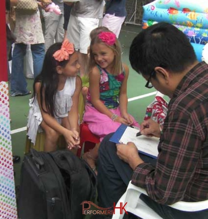 Caricaturist drawing two little girls