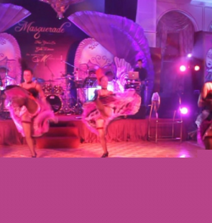 dancers performing kicks in purple backdrop at a ball