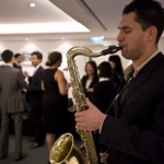 Sax player delivering soulful music at a dinner event. 