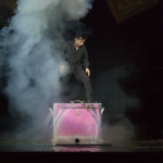 Wing performing illusion magic on stage.