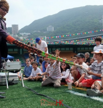 Hong Kong Magician performing with the magic glove , and the kid is trying to pull that off at a Corporate family day