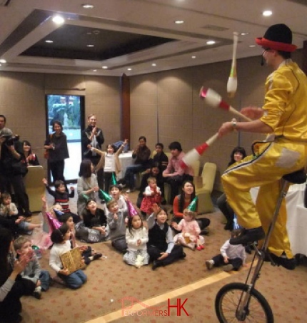 Hong Kong Unicyclist performing three cups juggling on the unicycle at a Family day event