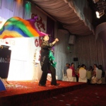 Wing waves around a colorful cloth during his stage magic show.