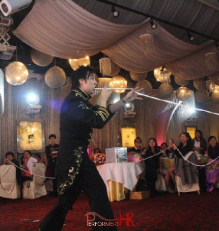 Roving magician pulling magic paper form his mouth and interact with the audience at a corporate event in Hong Kong