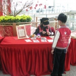 Chinese New Year event at Hong Kong Airport. Artist making Chinese knotting for child.