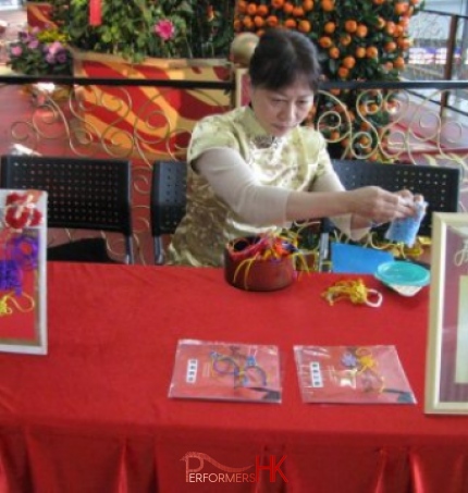 Hong Kong Professional artist in Chinese costume making Chinese Knot giveaway on site at a corporate Chinese new year event