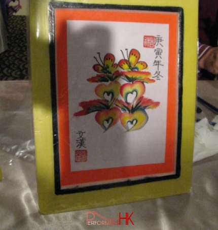 Hong Kong artist draw a rainbow calligraphy "SI" , using heart , flower and butterfly to replace the stroke at a wedding