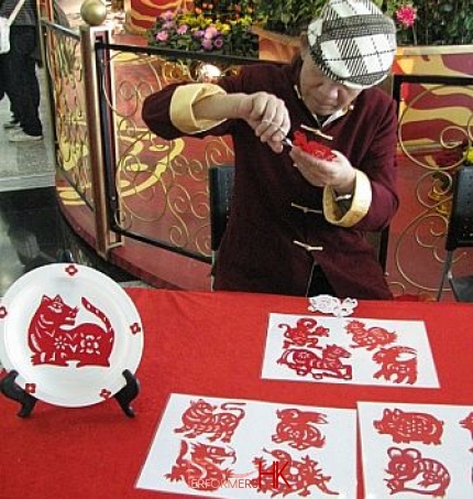 Zodiac paper cutting artist cutting Chinese zodiac animal from a red paper at Hong Kong airport 
