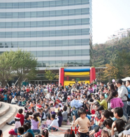 Performers on Cyberport podium for a clown  show being watched by a huge crowd