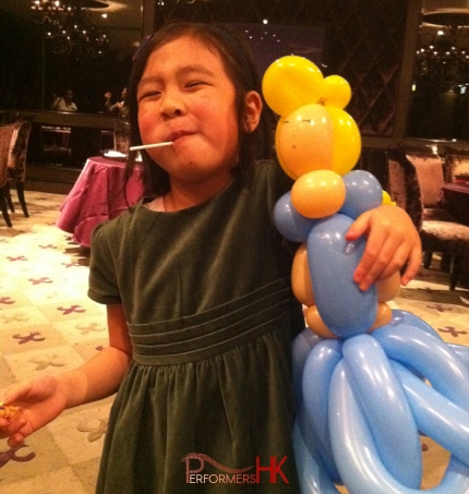 Walk around balloonist in HK twisted a Cinderella balloon for a children at a birthday party.
