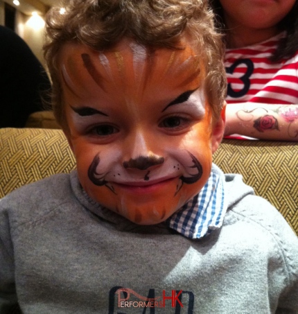 A little guest from a corporate family seems very happy with his new tiger face paint by a Hong Kong face paint artist