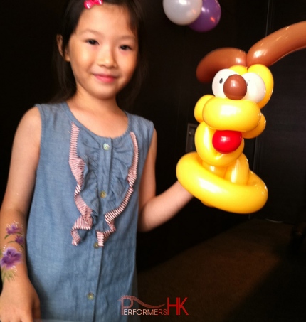 HK roving balloons artists twist a Pluto balloon for a kid at a event