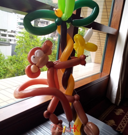 Roving balloon clown twisted a monkey balloon which holding a balloon banana, climbing on a balloon tree for a corporate family day client in Hong Kong