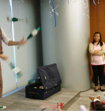 Roving juggler in HK juggling three cups at a corporate xmas event
