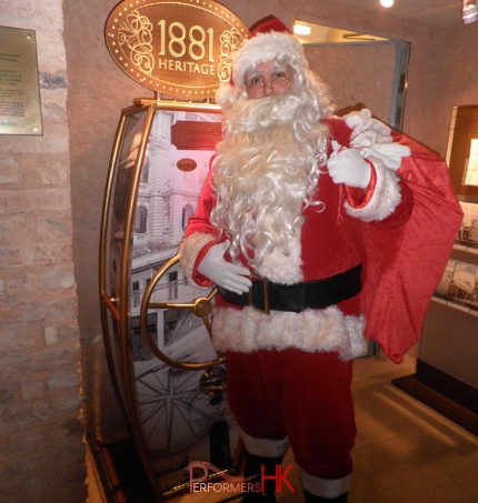 Santa holding bag infront of sign