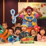 Tony the clown poses with kids at a party. 