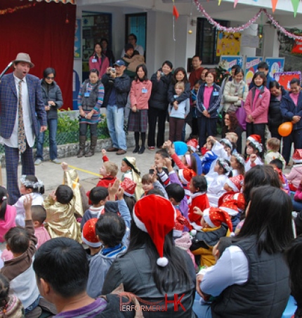 The juggler asking for a volunteer and a lot of the audience putting their hands at a Hong Kong Christmas event