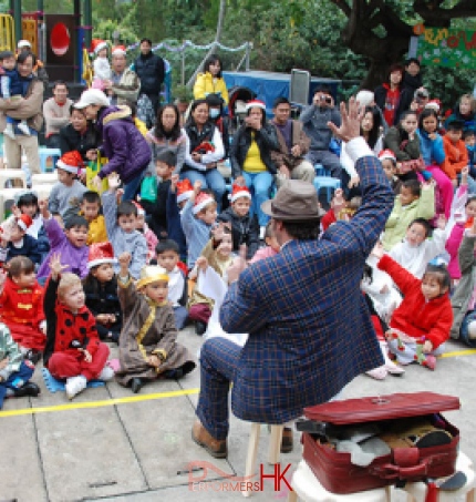 Performer in HK putting his right hand up to the air and the audience is coping him at a corporate family event