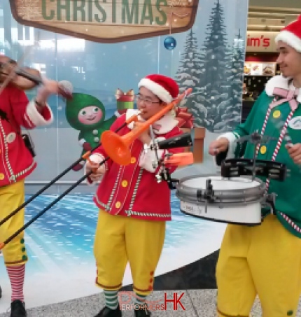 Three walk around musicians playing the violin drum and trombone at the HK Airport