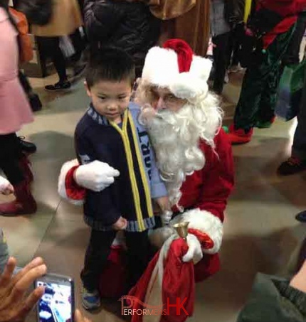 Santa in Hong Kong Sogo hotel having picture taken with child.